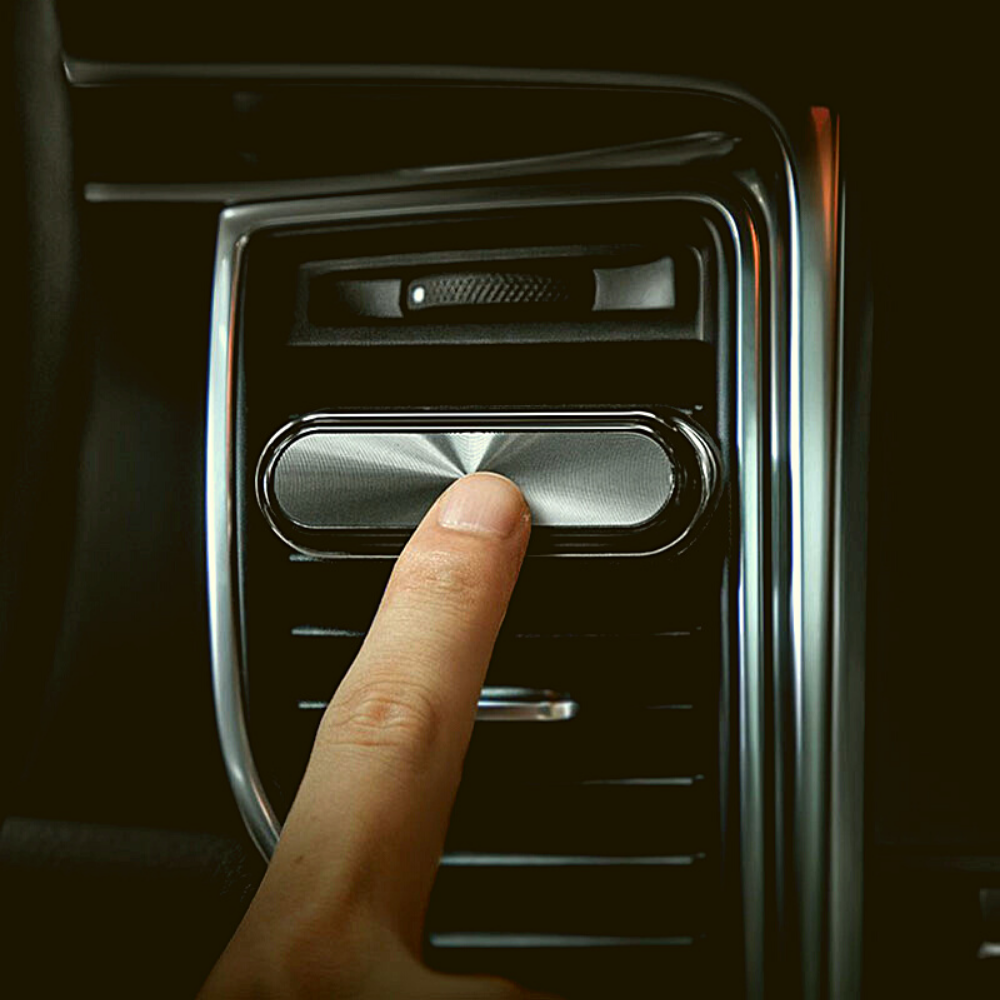 Finger touching Smul luxury car air freshener on & off switch.
