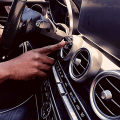 Smul luxury car freshener on a Mercedes C300 fan vent. Driver is switching the unit on so the scent disperses in the car cabin.